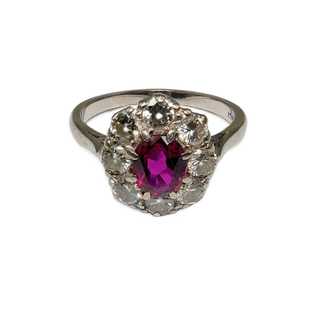 An 18ct white gold, ruby and diamond set oval cluster ring